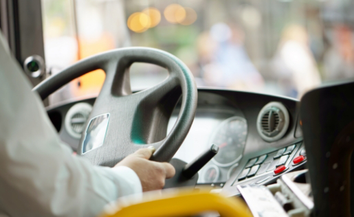 Mann am Steuer eines Busses, Blick aus der Fahrerkabine