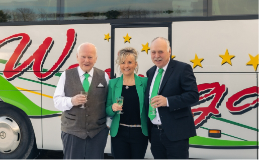 Familie Weingart vor dem Weingart Reisebus mit Sekt in der Hand