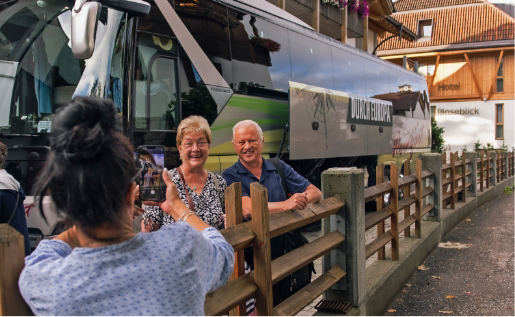 Rentnerehepaar neben Weingart Reisebus